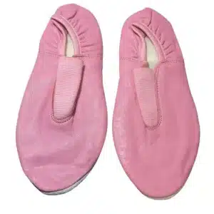 Close-up detail of the elastic strap and interior lining of a pink leather gymnastic slipper.
