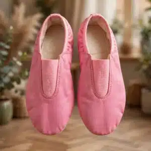 Pink leather gymnastic ballet slippers top view product showcase in aesthetic dance studio scenery with wooden floor and warm bokeh lights - 600x900 banner no models